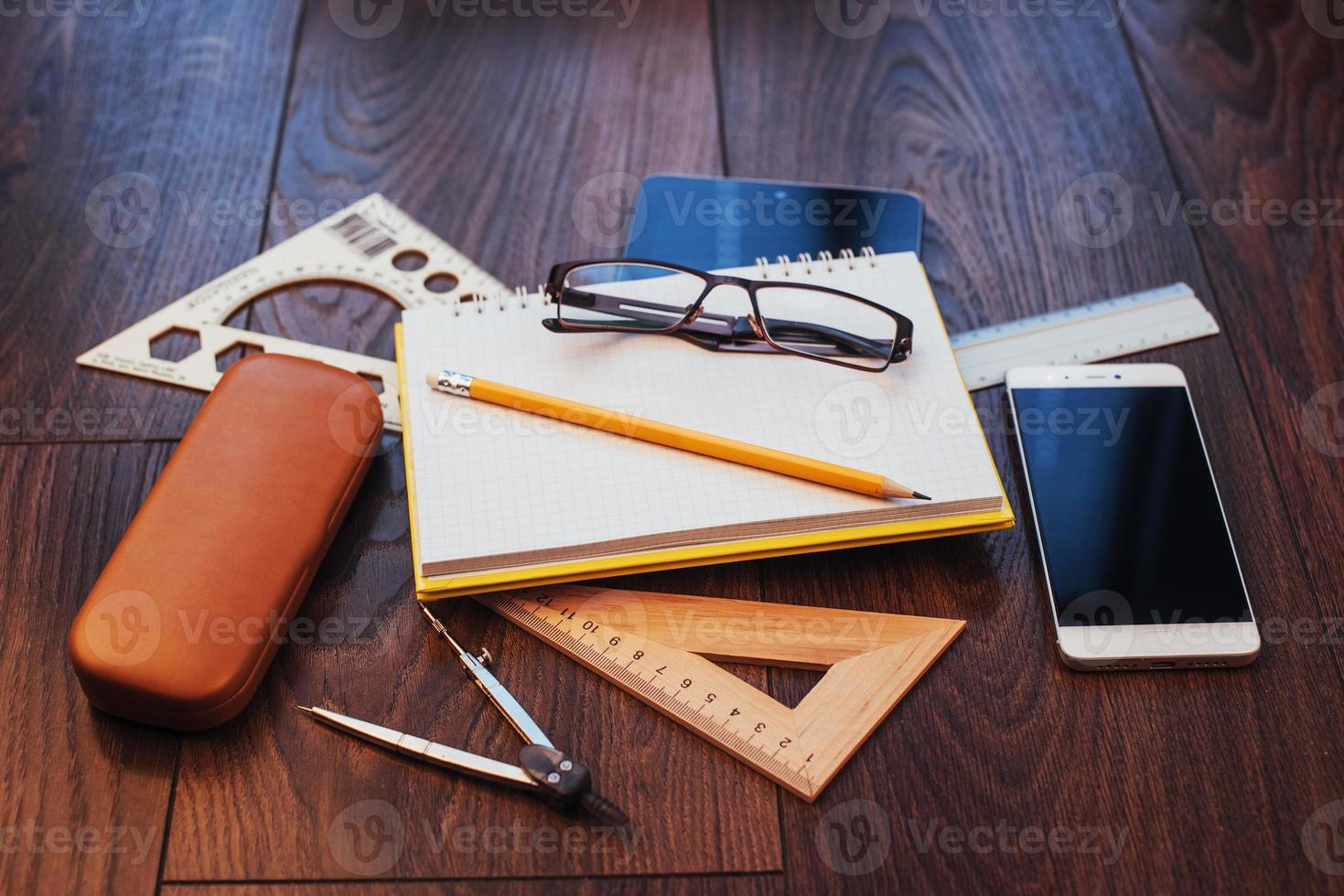 bovenaanzicht van notebook, briefpapier, tekenhulpmiddelen en een paar glazen. improviseren. foto