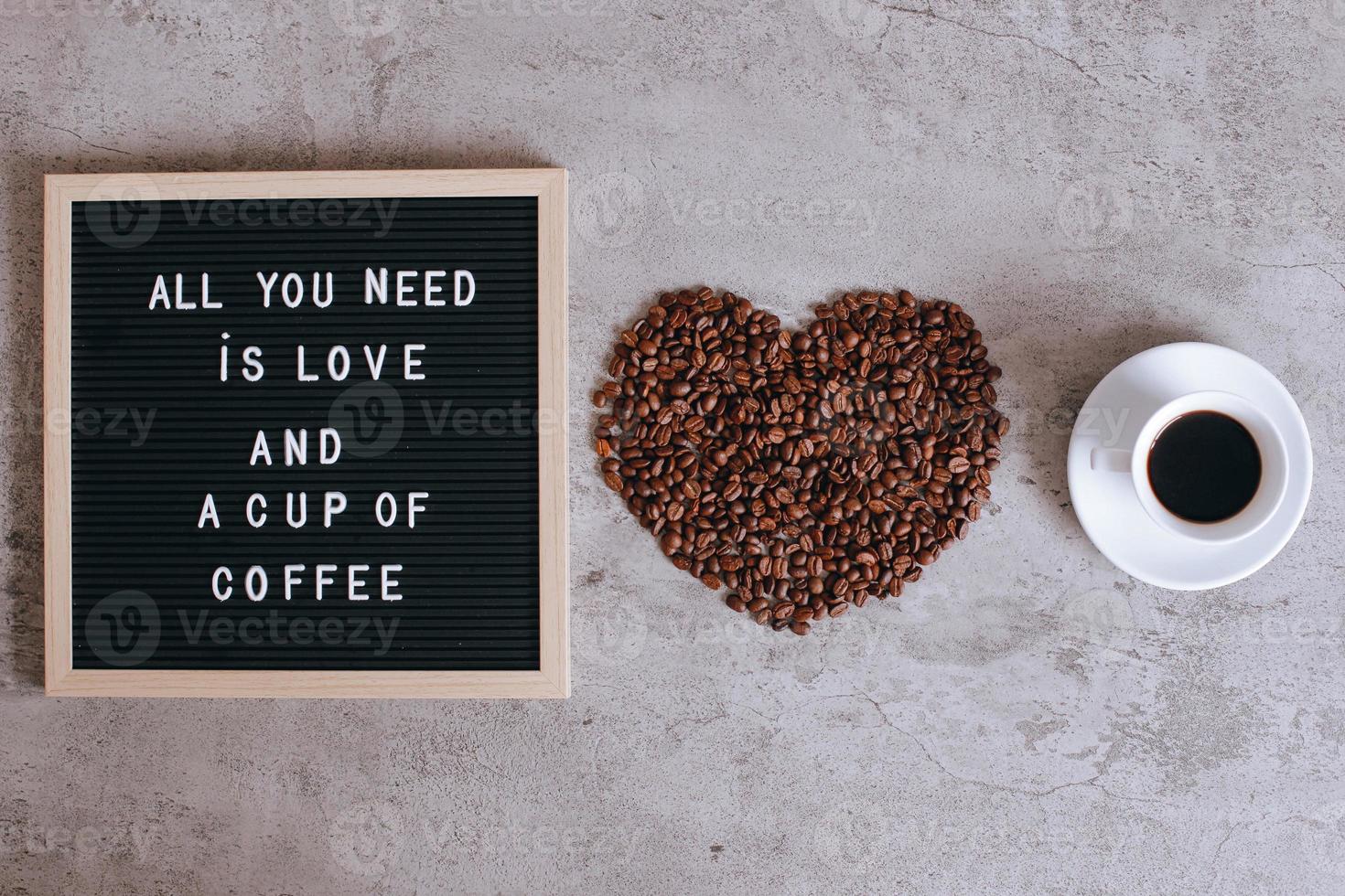 bovenaanzicht van een kopje koffie en hartvorm van koffiebonen met citaat op letterbord, alles wat je nodig hebt is liefde en een kopje koffie foto
