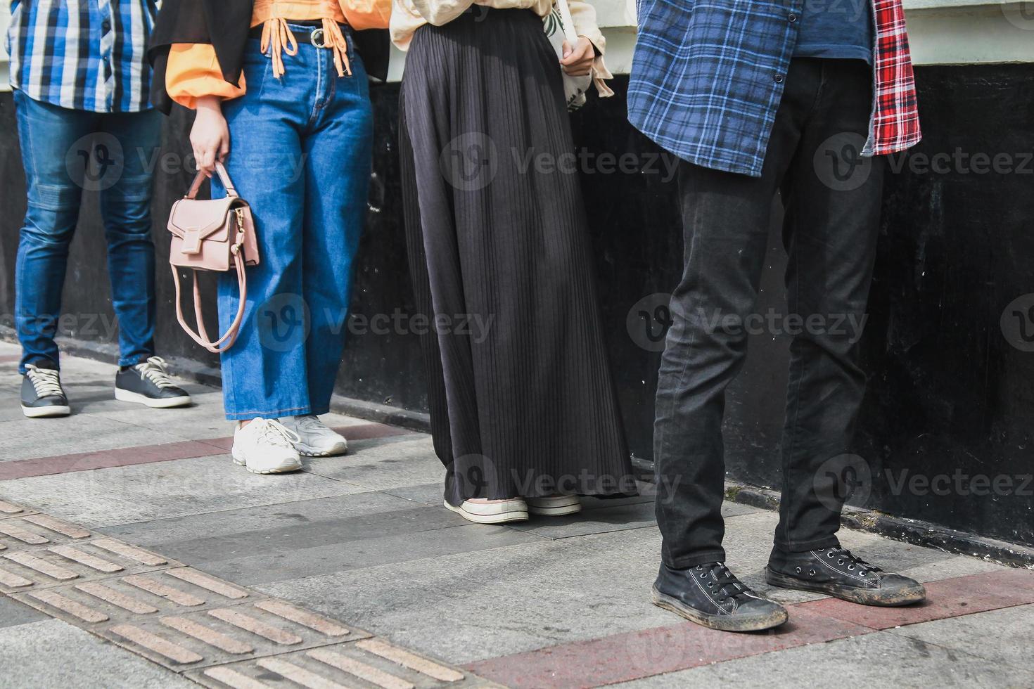 sociaal afstandsconcept met mensen in de rij. onherkenbare gezichten, close-up op de voeten van jonge mensen die de wet respecteren voor een pandemische ziekte van het coronavirus foto