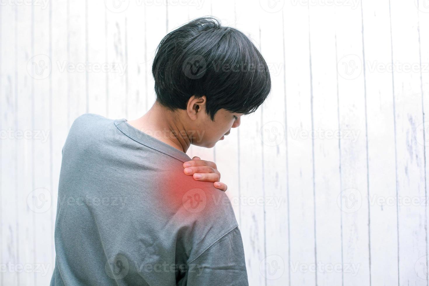 mensen, gezondheidszorg en probleemconcept - ongelukkige jonge man die thuis lijdt aan nek- of schouderpijn foto
