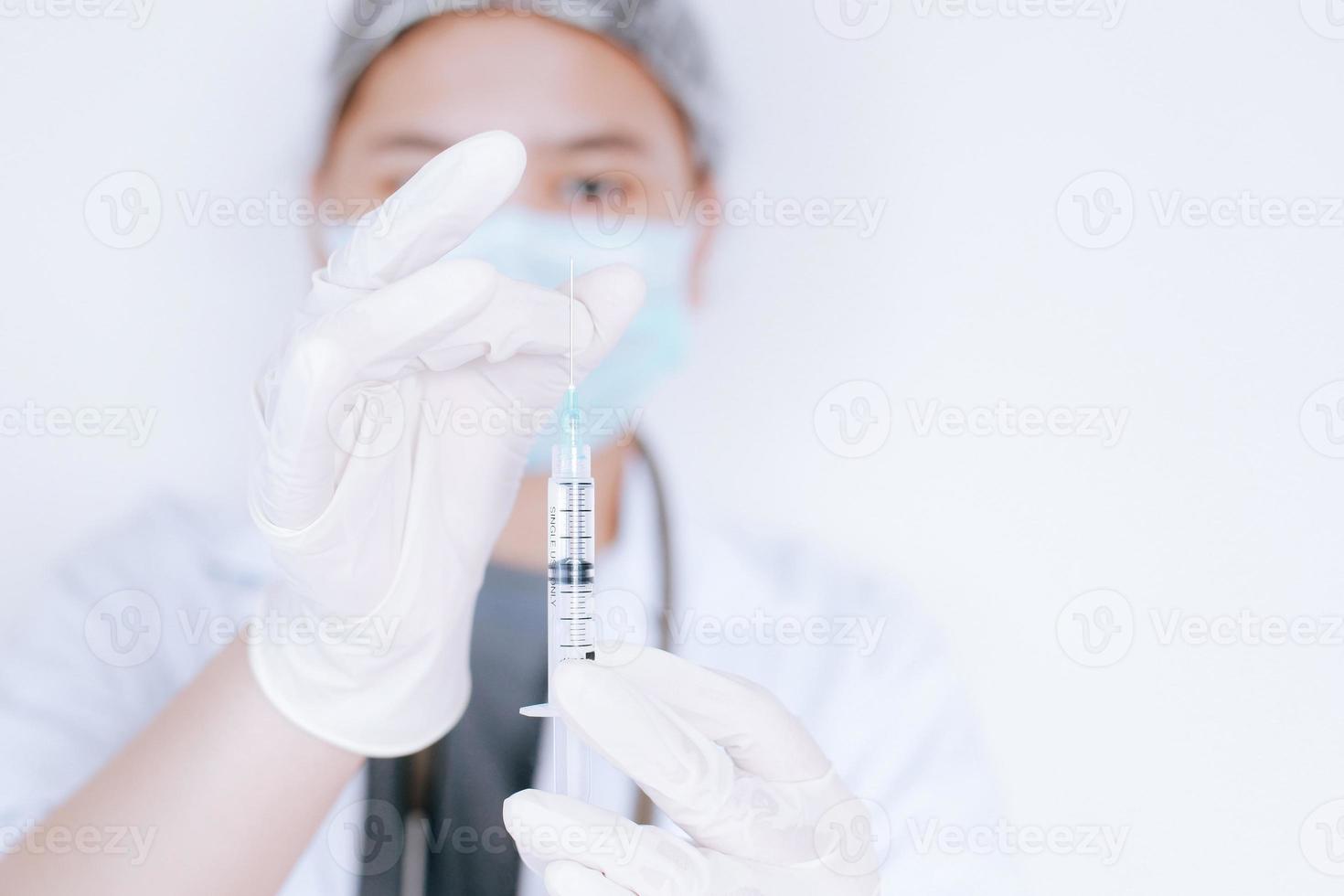 geneeskunde, vaccinatie en gezondheidszorg concept. Aziatische vrouwelijke arts of wetenschapper in masker met spuit op witte achtergrond foto
