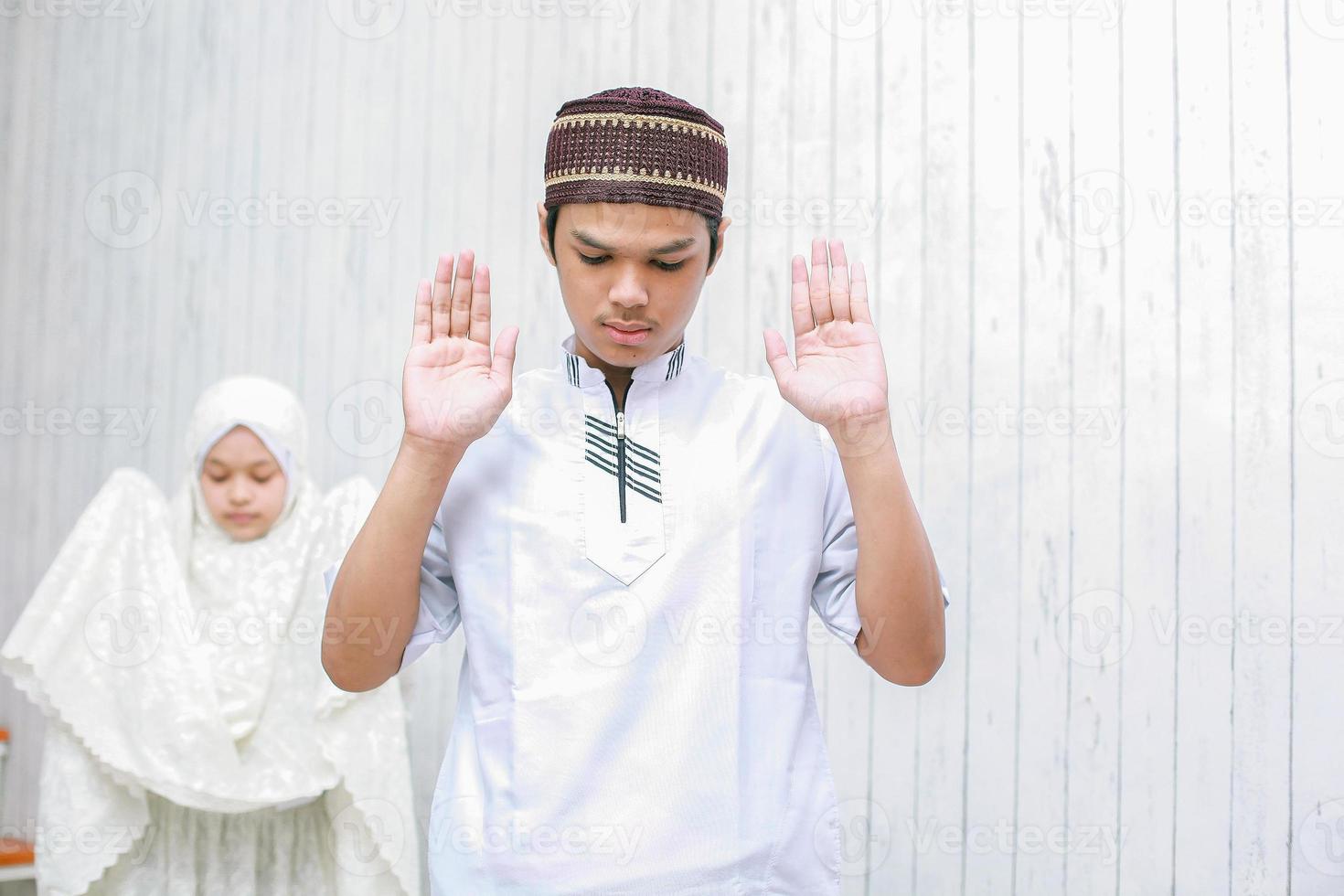 jong koppel moslim doet salah samen met het opsteken van zijn hand of takbiratul ihram pose foto