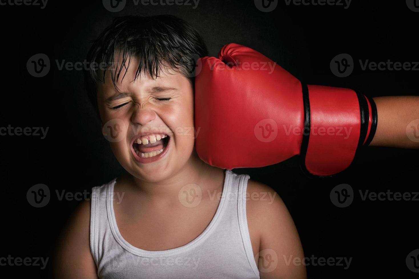 kleine jongen krijgt een klap van boksbol foto
