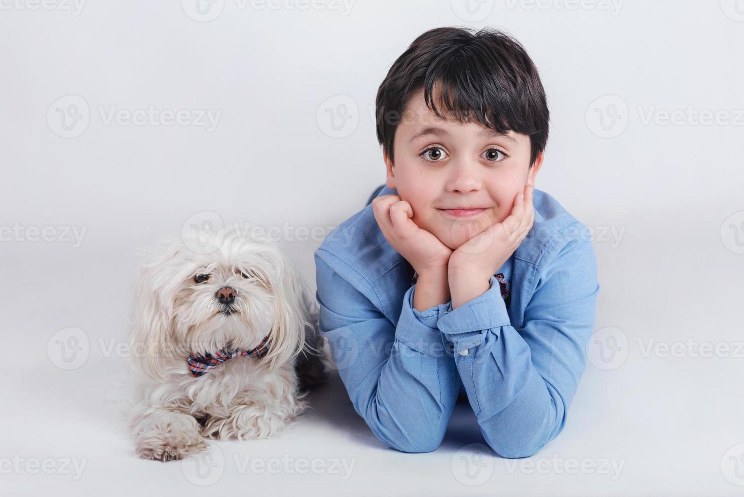 jongen die naast zijn hond ligt foto