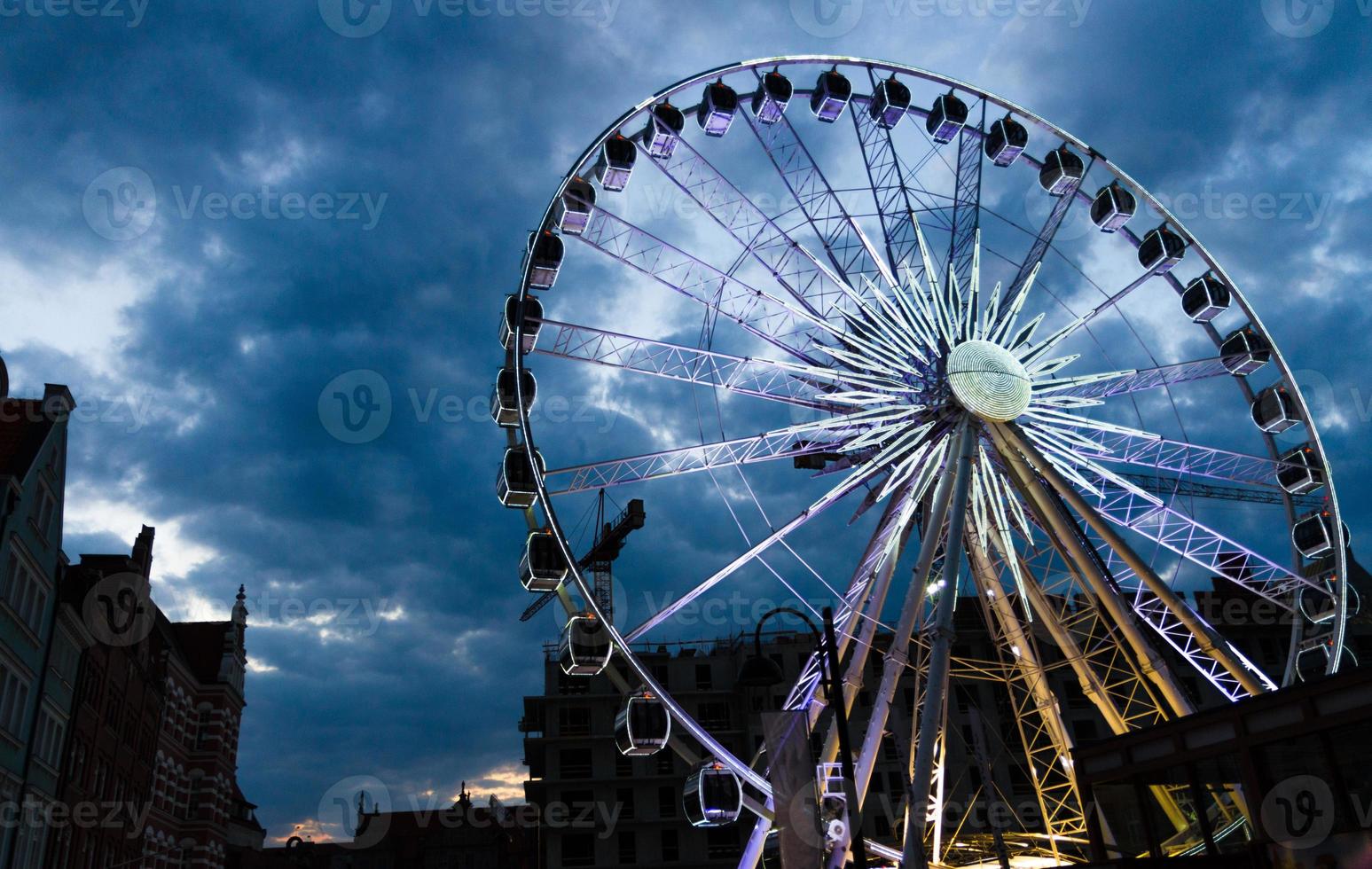 groot lichtgevend reuzenrad voor donkerblauwe dramatische hemel foto