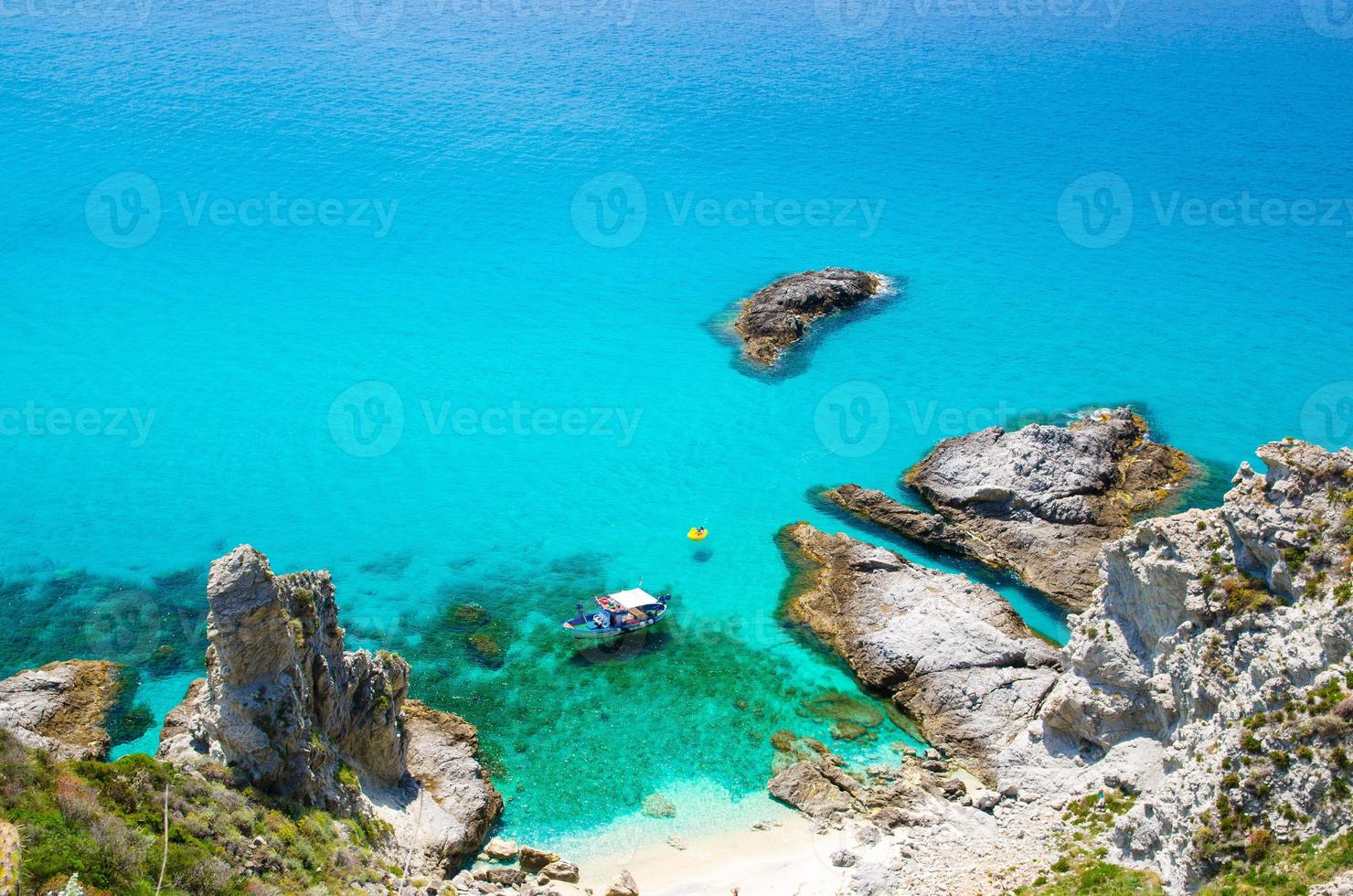 vissersjacht en rubberboot in de lagune van capo vaticano, calabria, italië foto