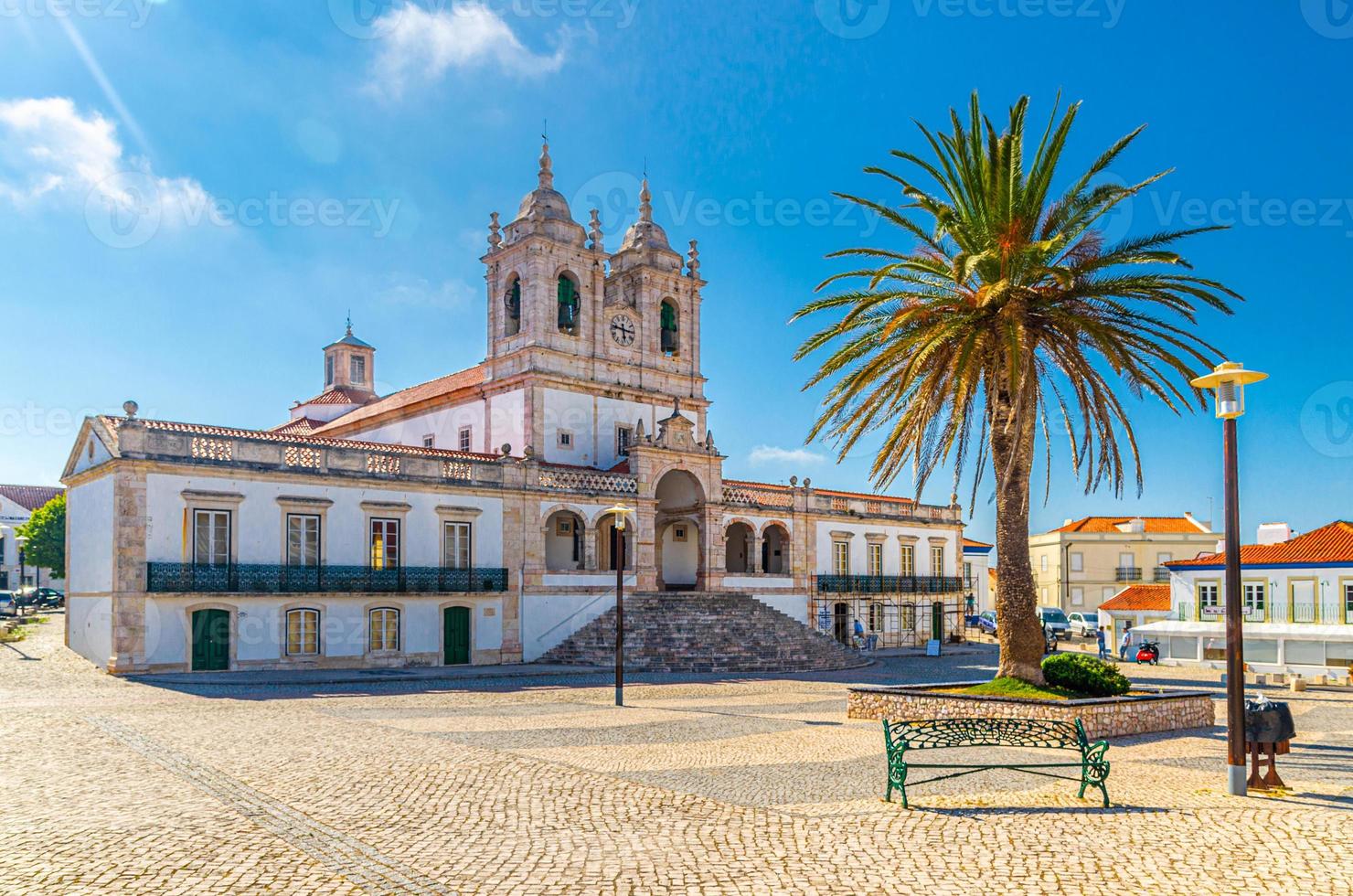 heiligdom van onze lieve vrouw van nazare katholieke kerk in geplaveid plein met palmbomen in sitio heuveltop da nazare stad foto