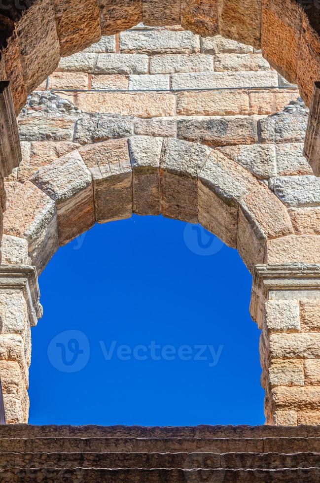 blauwe heldere lucht door kalkstenen boograam van de arena van verona foto