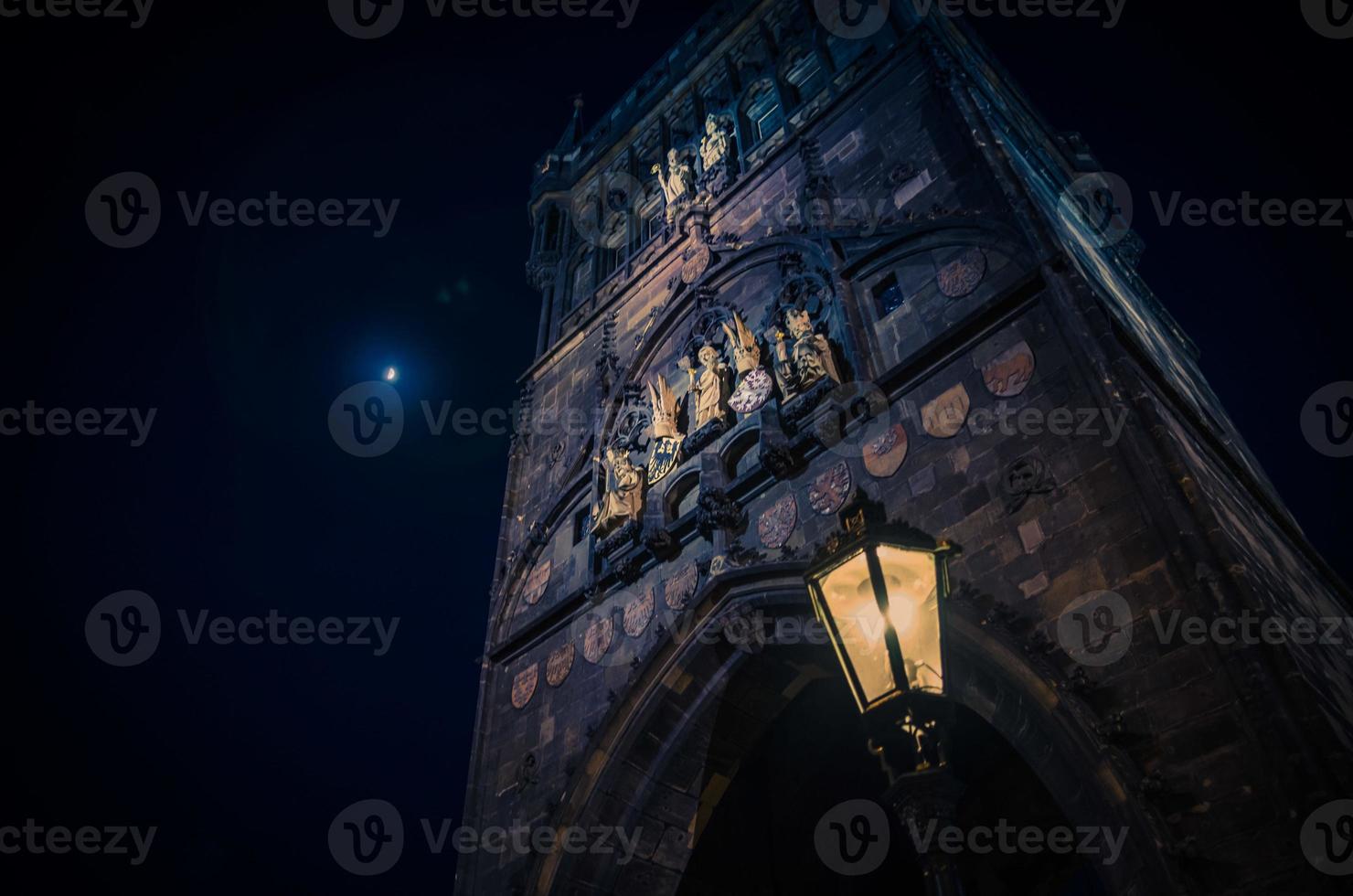 wassende maan in de avondlucht over de nacht, de brugtoren van de oude stad van Praag foto