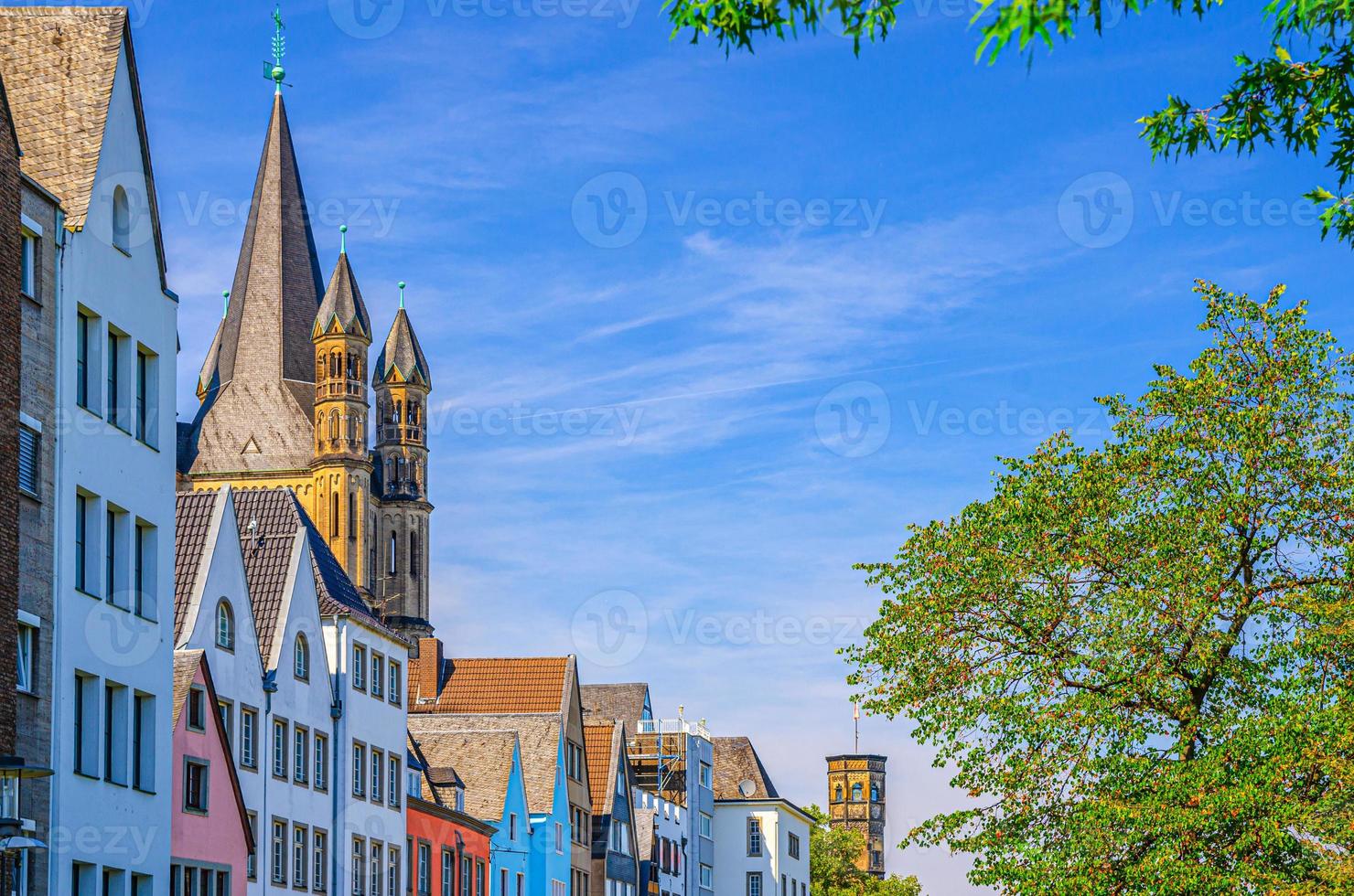 rij kleurrijke gevelgebouwen, grote rooms-katholieke kerktoren van heilige martin foto