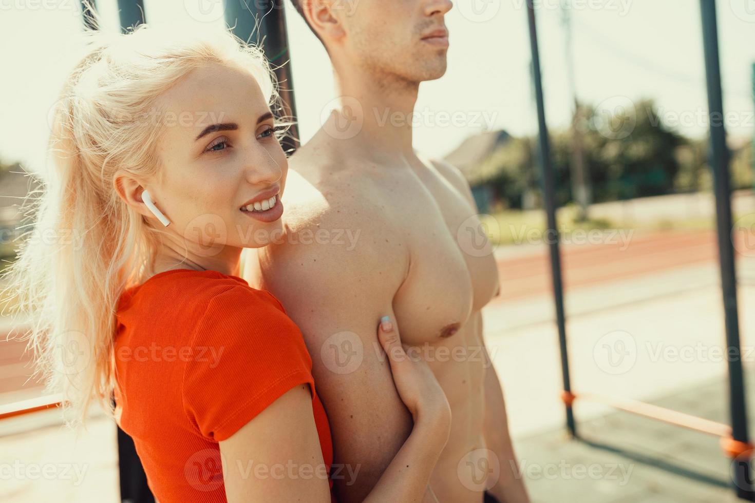 schattige blondine knuffelt haar atletische vriendje foto