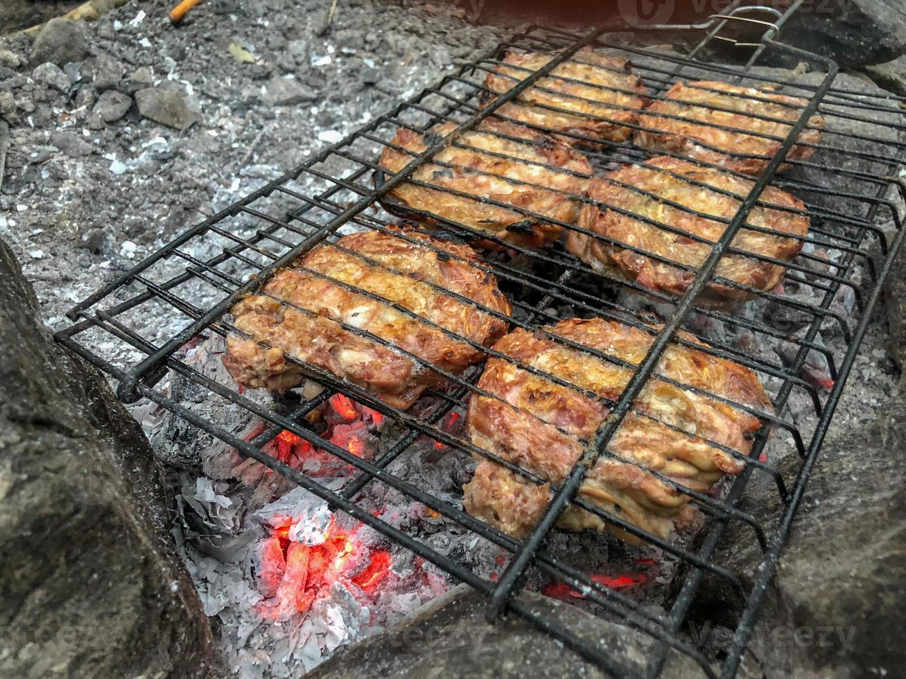 bosbarbecue gegrild voedsel in brand, heerlijk koken in kampvuur, barbecue gegrild kororec in brand foto