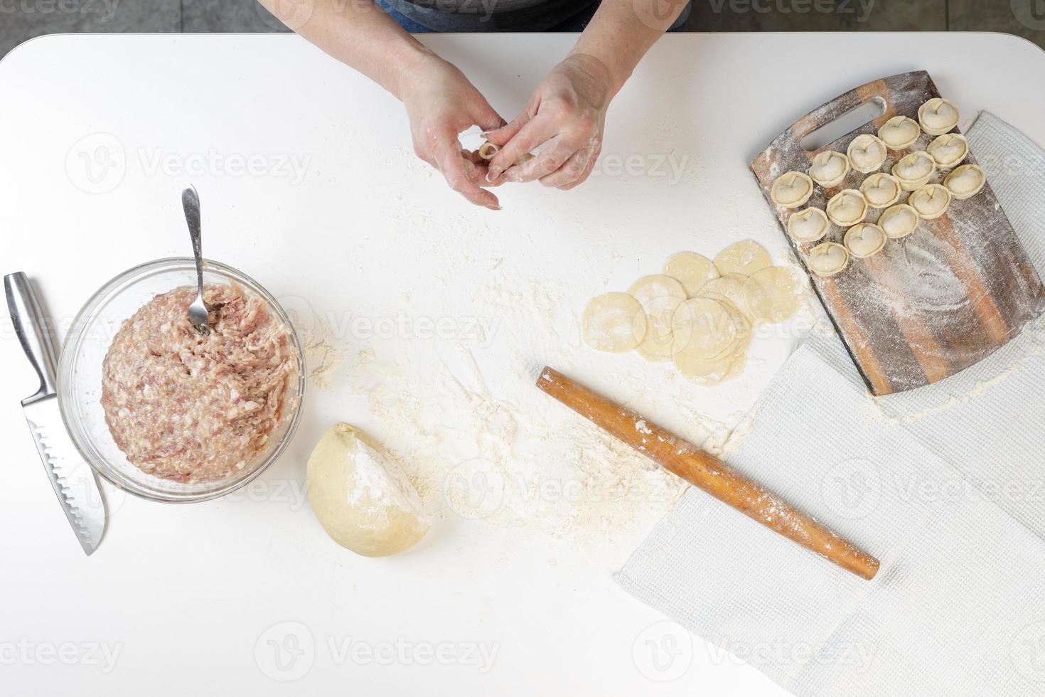 zelfgemaakte dumplings in de keuken zonder versieringen. dumplings maken met varkensgehakt, rundvlees en kip foto