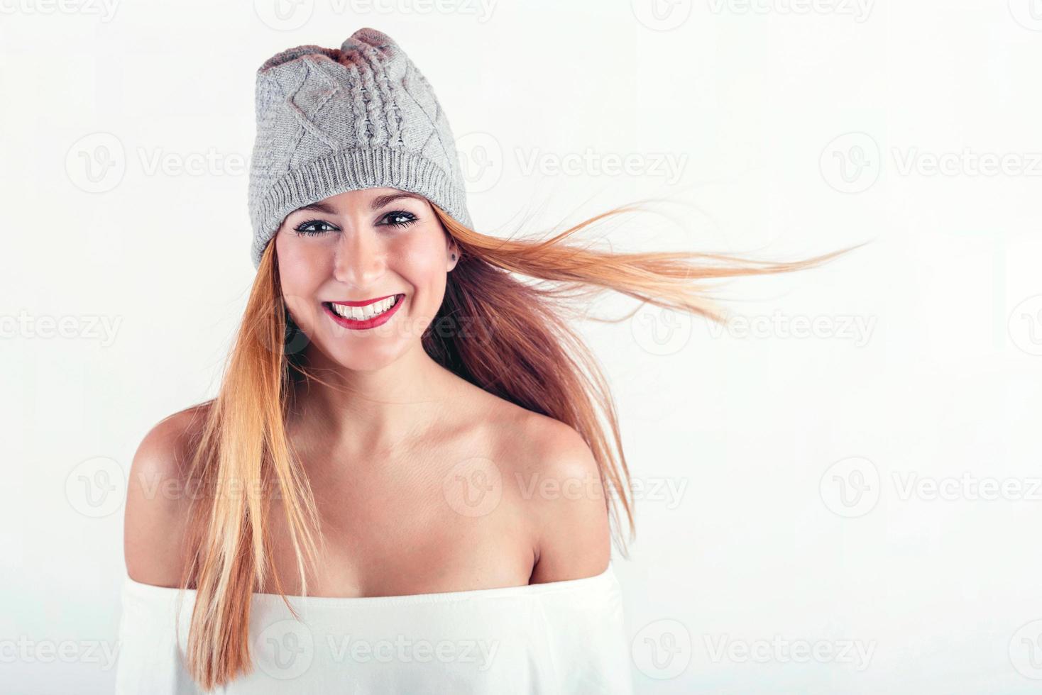 lachende jonge vrouw met wintermuts foto