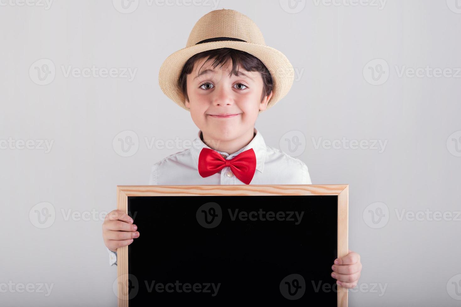 gelukkige jongen met een schoolbord met hoed en vlinderdas foto