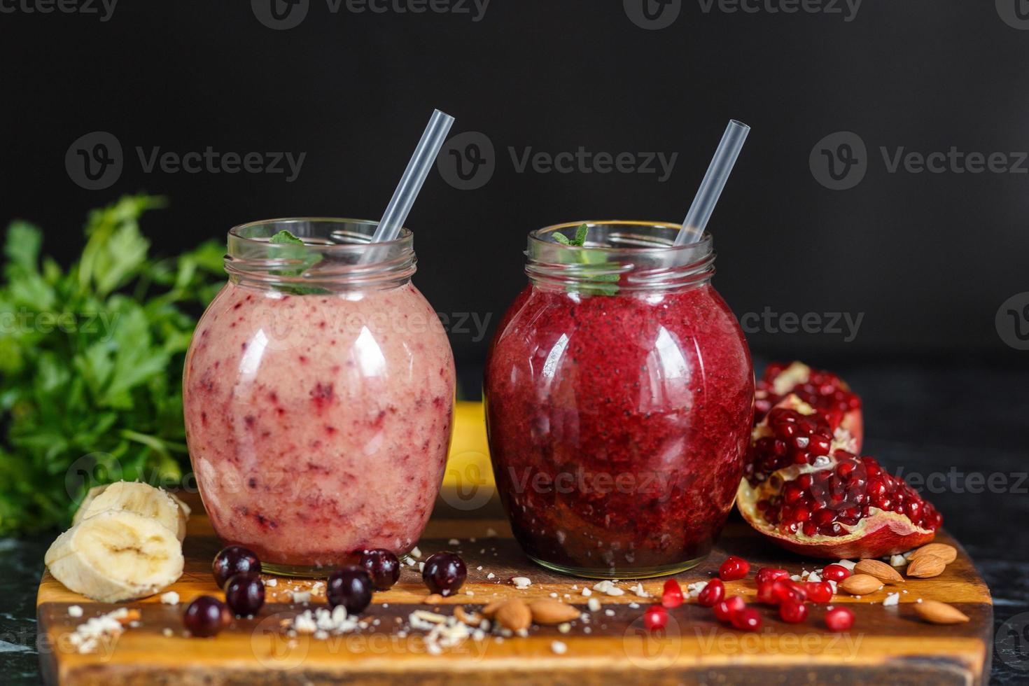 vers bereide smoothies van banaan met granaatappel en banaan met braambes in fles. dieet, gezonde levensstijl foto