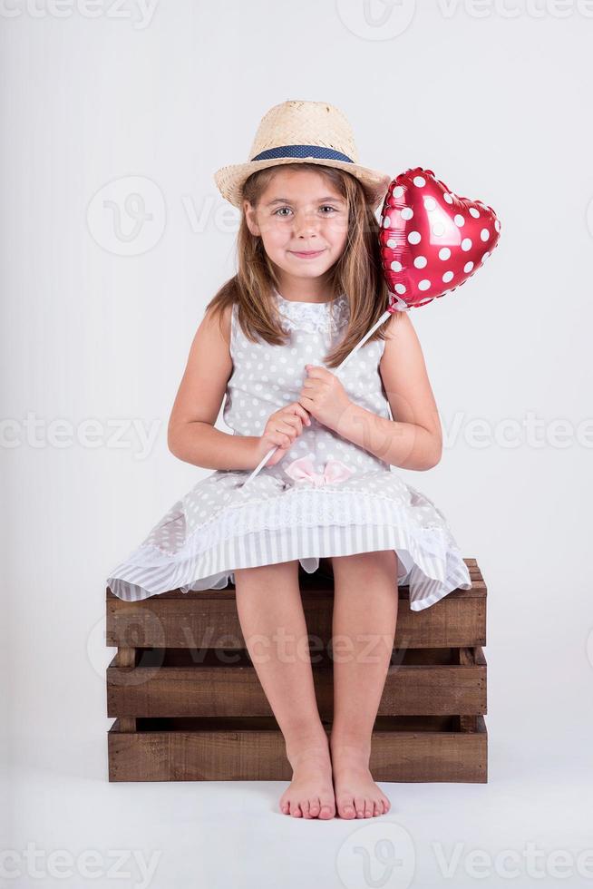 gelukkig meisje met een hartvormige ballon foto