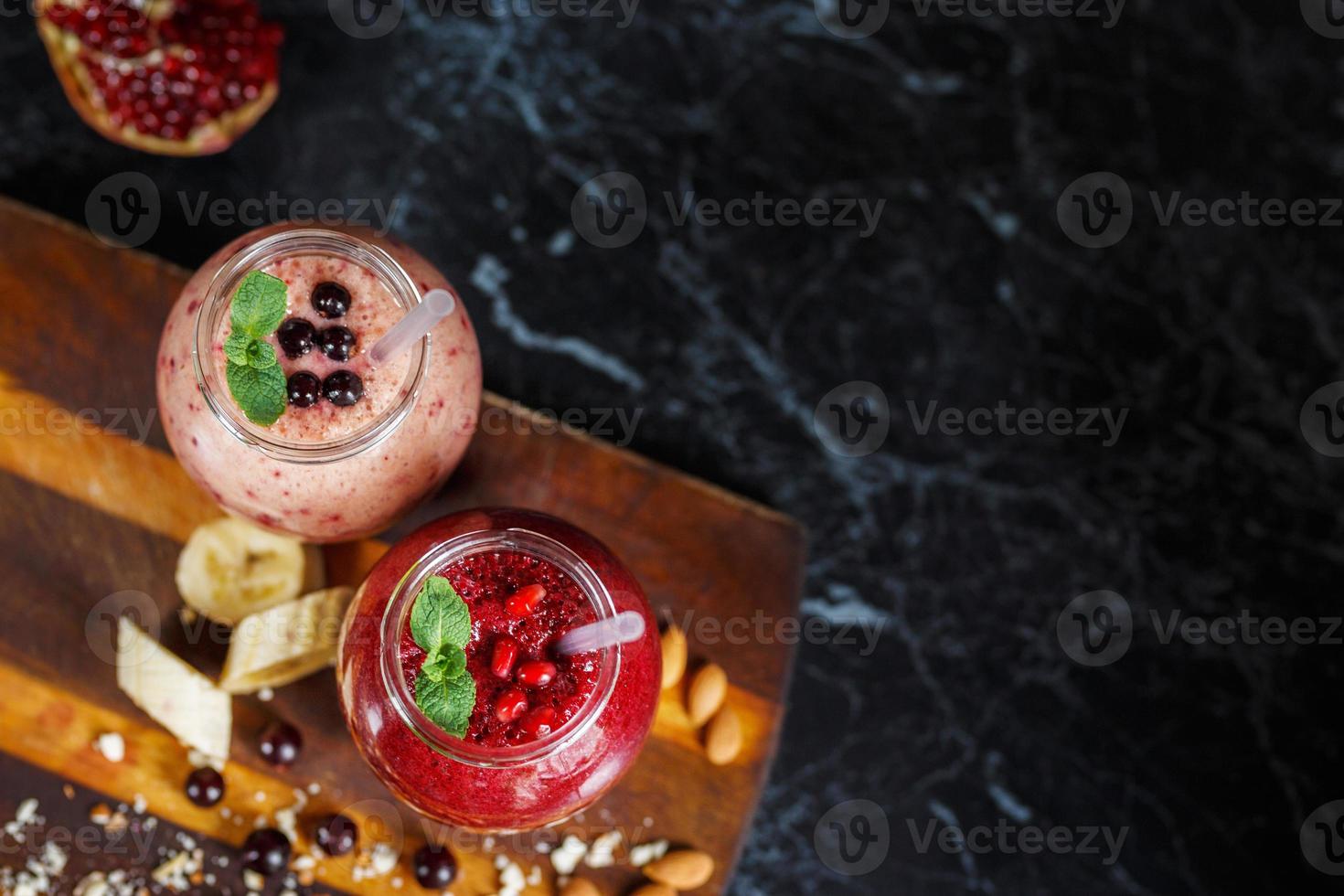 vers bereide smoothies van banaan met granaatappel en banaan met braambes in fles. dieet, gezonde levensstijl foto