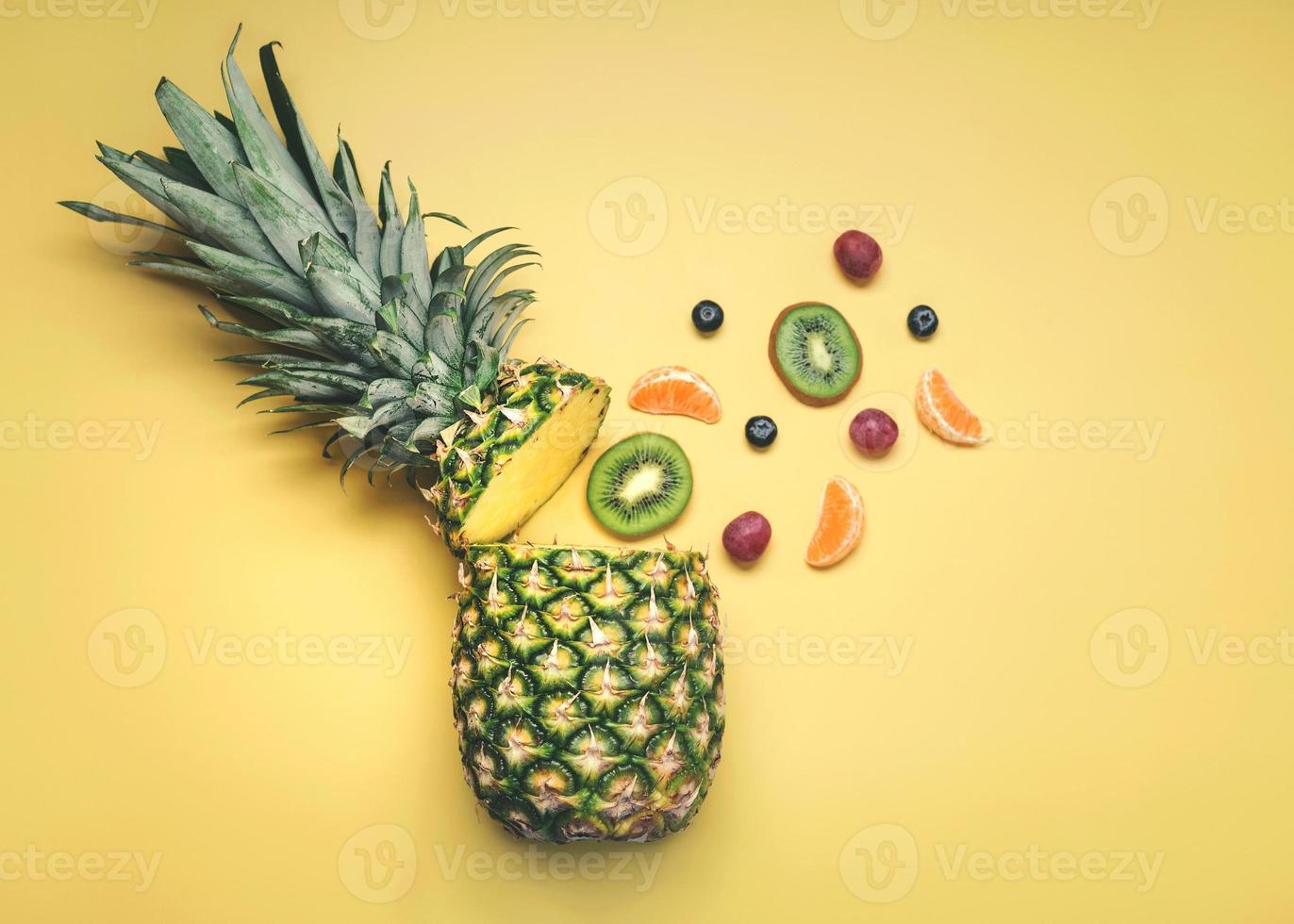 ananas met verschillende soorten fruit, sinaasappels, kiwi's, druiven en bosbessen foto