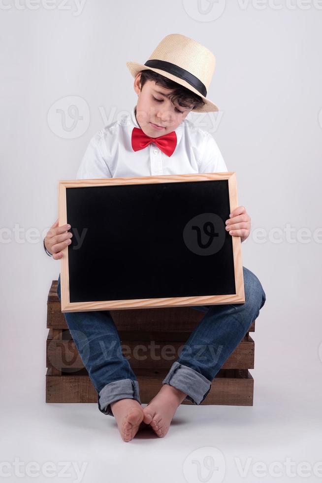 nadenkende jongen met een schoolbord foto