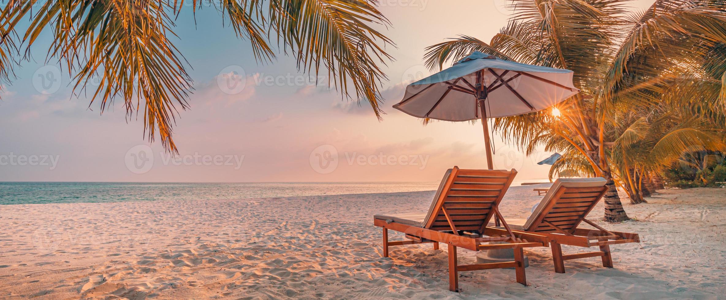 geweldig romantisch strand. stoelen op het zandstrand in de buurt van de zee. zomervakantie vakantie concept voor toerisme. tropisch eiland landschap. rustig kustlandschap, ontspannen kusthorizon, palmbladeren foto