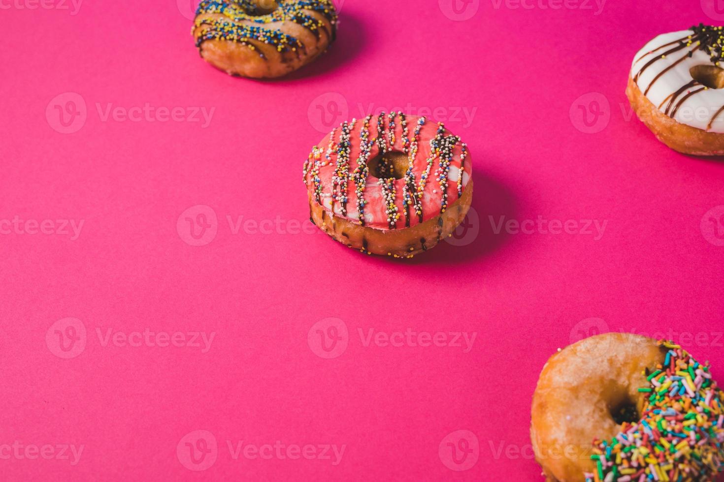 close-up van een roze donut op een roze achtergrond foto