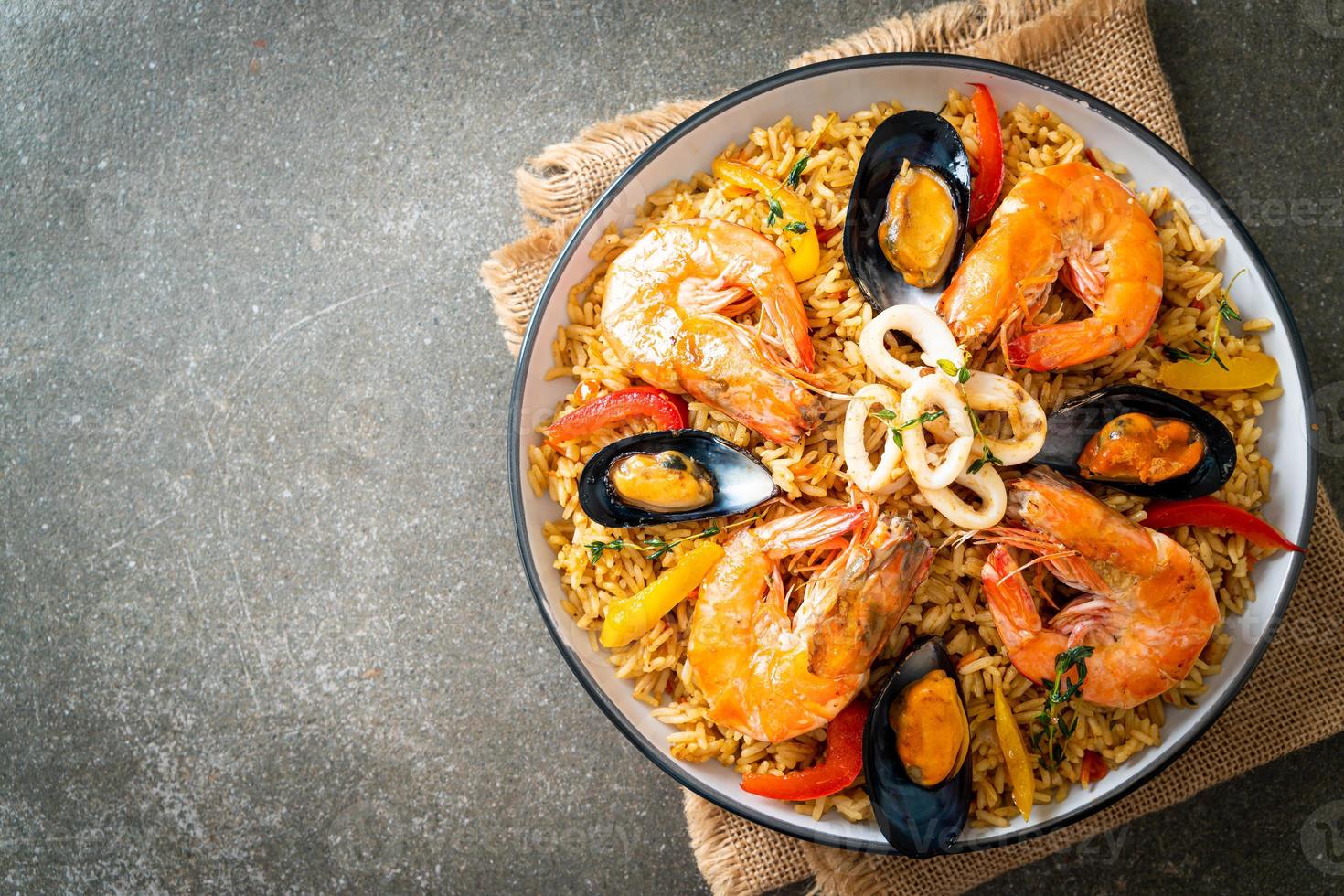 zeevruchtenpaella met garnalen, kokkels, mosselen op saffraanrijst foto