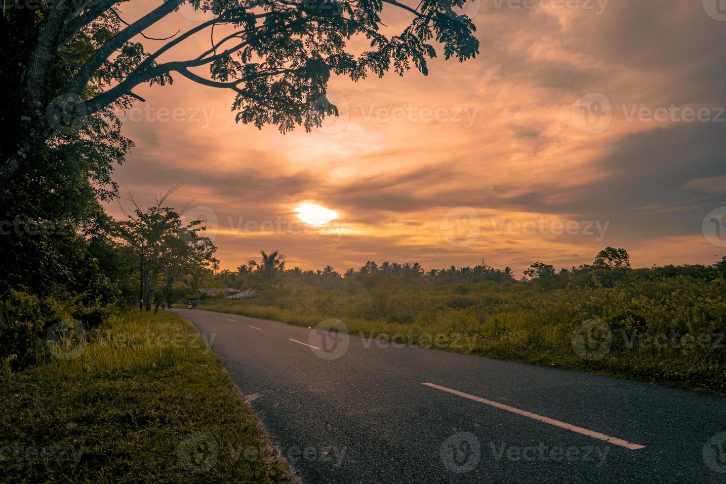 landelijk zonsonderganglandschap met lege weg foto