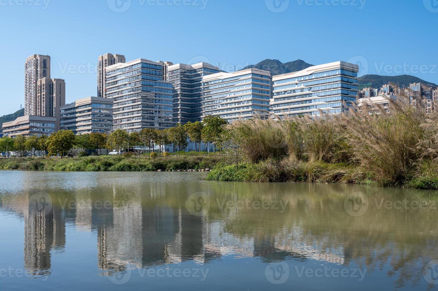 de rivier weerspiegelt de moderne stadsgebouwen onder de blauwe lucht foto