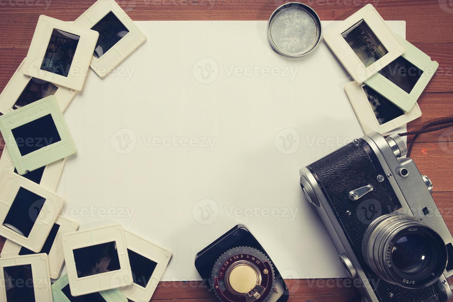 retro camera en enkele oude foto's op houten tafel foto