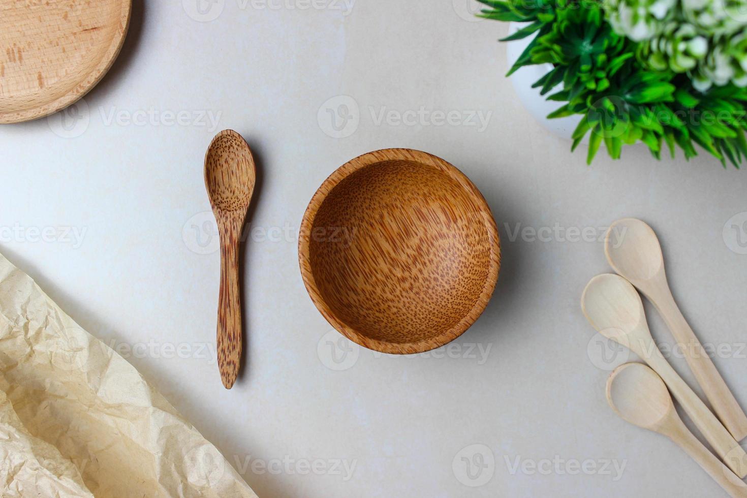 houten gebruiksvoorwerpen op de keukentafel. ronde houten platen, een houten lepel, een groene plant. het concept van serveren, koken, koken, interieurdetails. bovenaanzicht foto