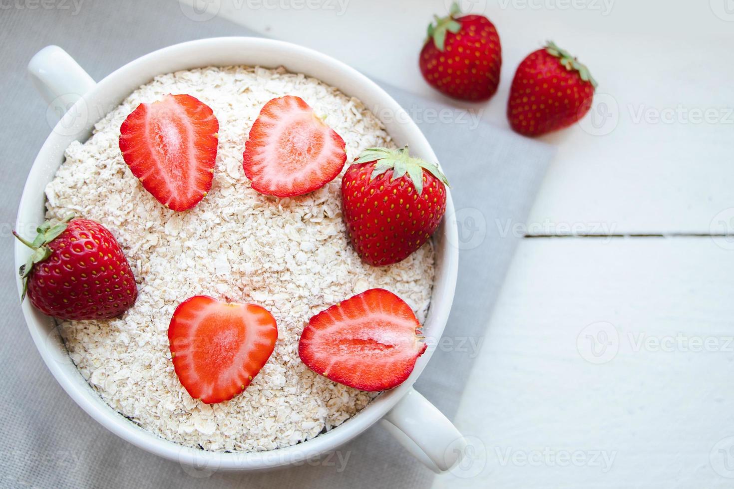 havermuesli en verse aardbeien op houten ondergrond. foto