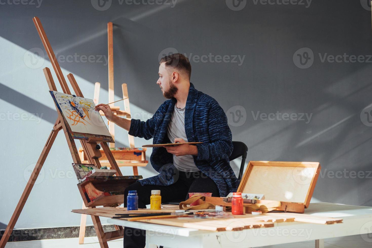 ontworpen door kunstenaar man afwerking van zijn meesterwerk houdt een borstel in de hand. foto