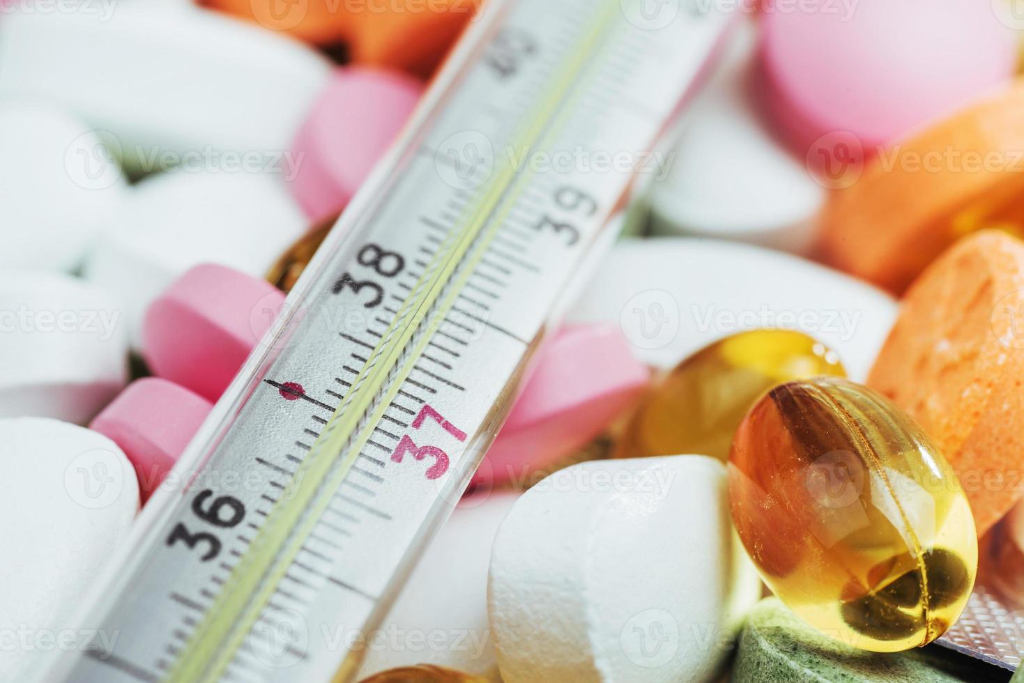 thermometer en verschillende gekleurde soorten pillen. medische gezondheid of drugs concept foto