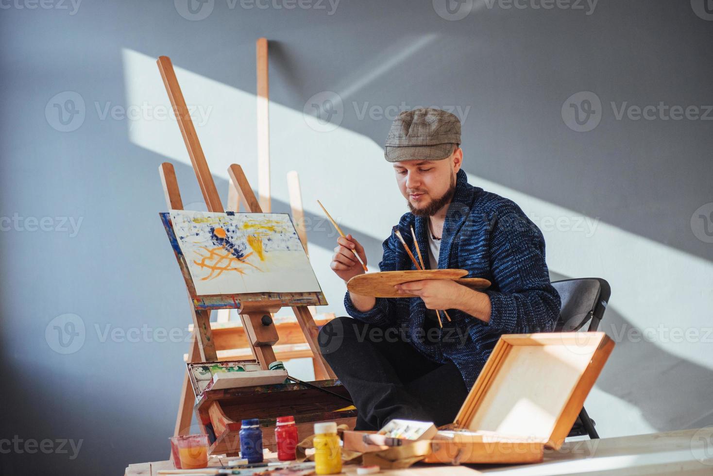 ontworpen door kunstenaar man afwerking van zijn meesterwerk houdt een borstel in de hand. foto