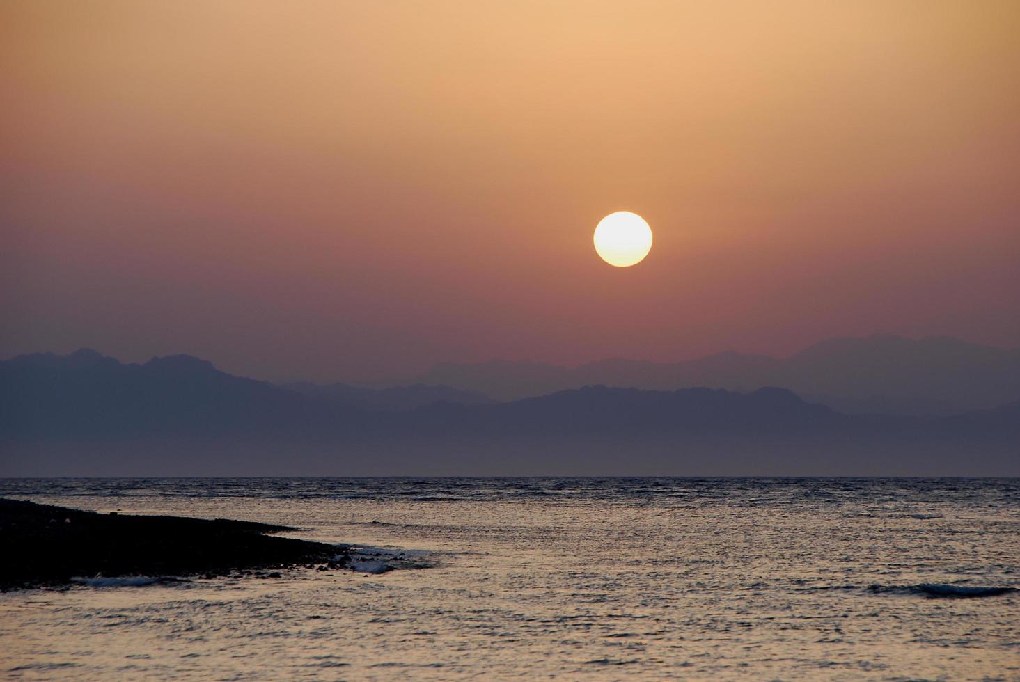 vredige glanzende zee bij zonsopgang in de zomer foto