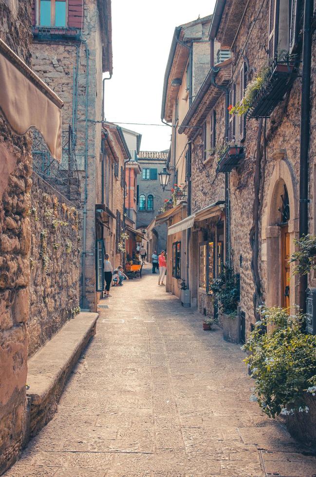 San Marino, 18 september 2018 typisch Italiaanse geplaveide straat met traditionele gebouwen en huizen met groene planten op muren in het oude historische stadscentrum foto