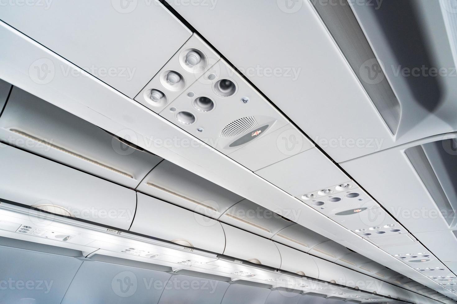 vliegtuig airconditioning bedieningspaneel over stoelen, benauwde lucht in vliegtuigcabine met mensen, nieuwe goedkope luchtvaartmaatschappij foto