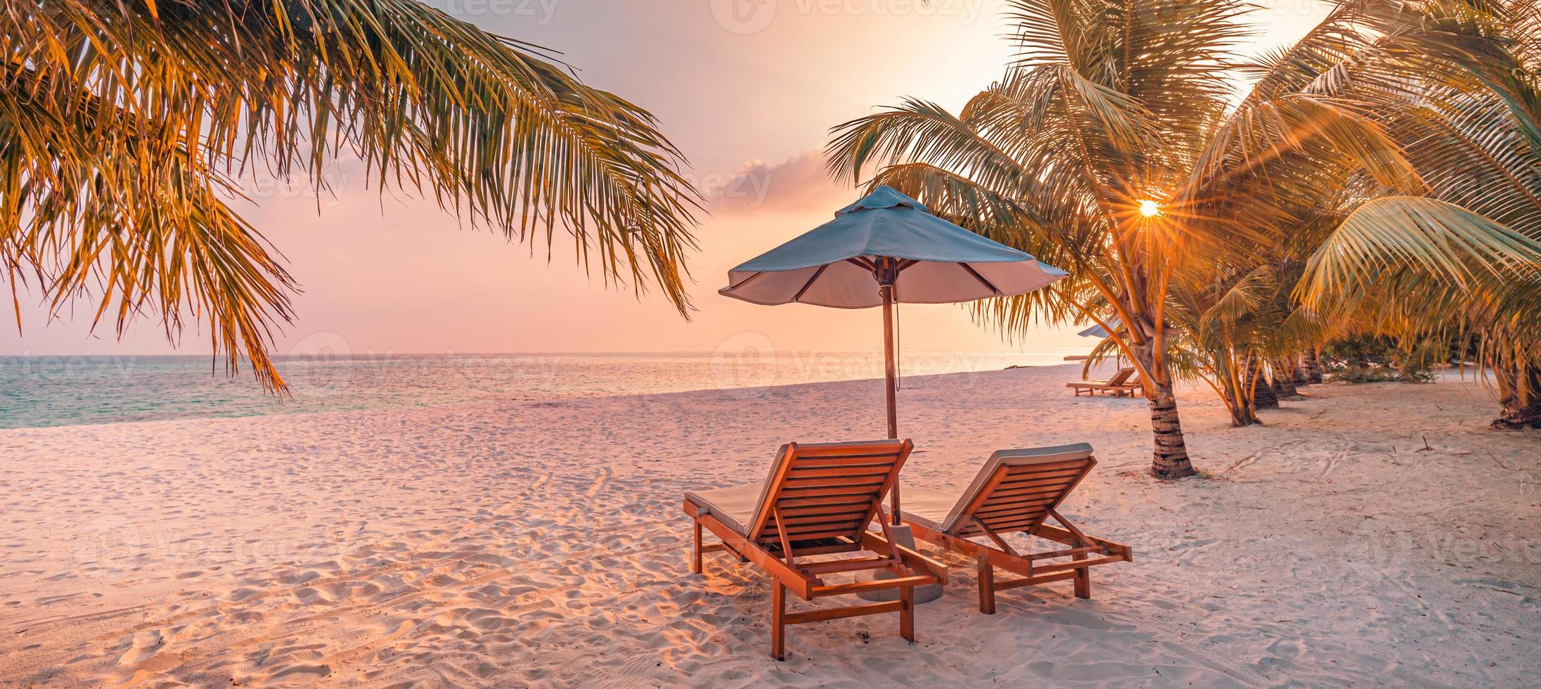 geweldig romantisch strand. stoelen op het zandstrand in de buurt van de zee. zomervakantie vakantie concept voor toerisme. tropisch eiland landschap. rustig kustlandschap, ontspannen kusthorizon, palmbladeren foto