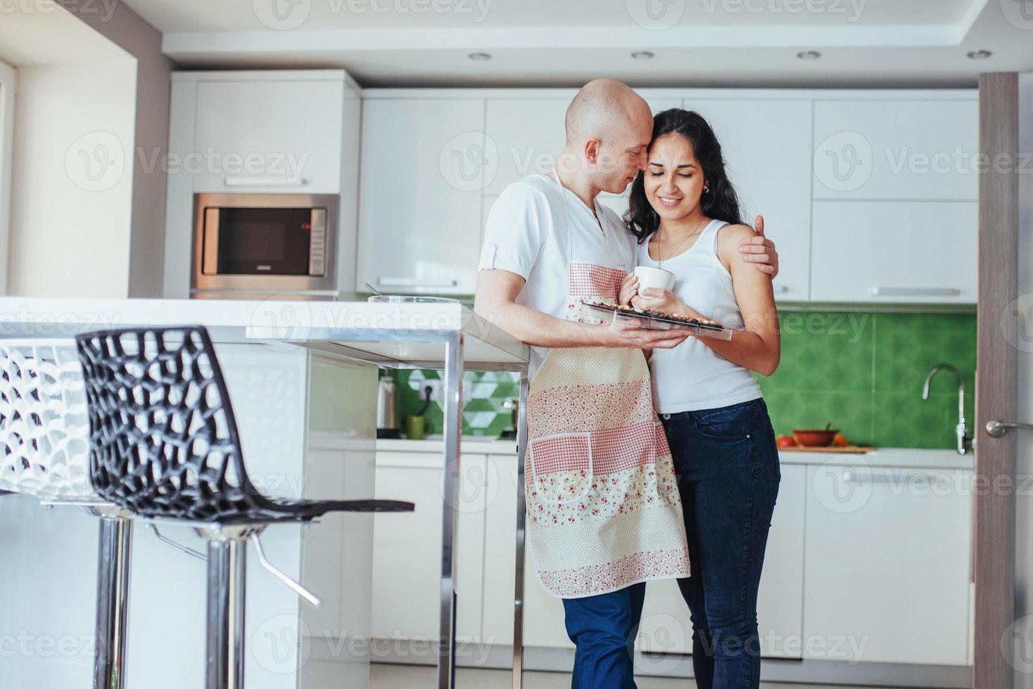 gelukkig jong koppel met koffie in de keuken foto