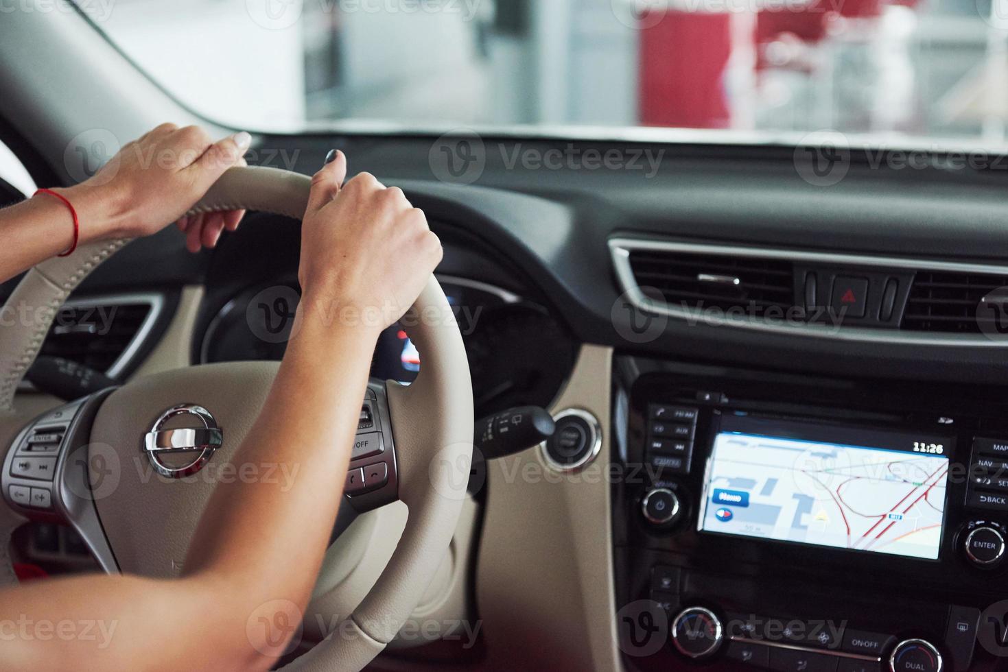 vrouw in auto binnen houdt wiel ronddraaiend glimlachend kijkend naar passagiers op de achterbank idee taxichauffeur tegen zonsondergang stralen licht glans hemel concept examen voertuig - tweede huis het meisje foto