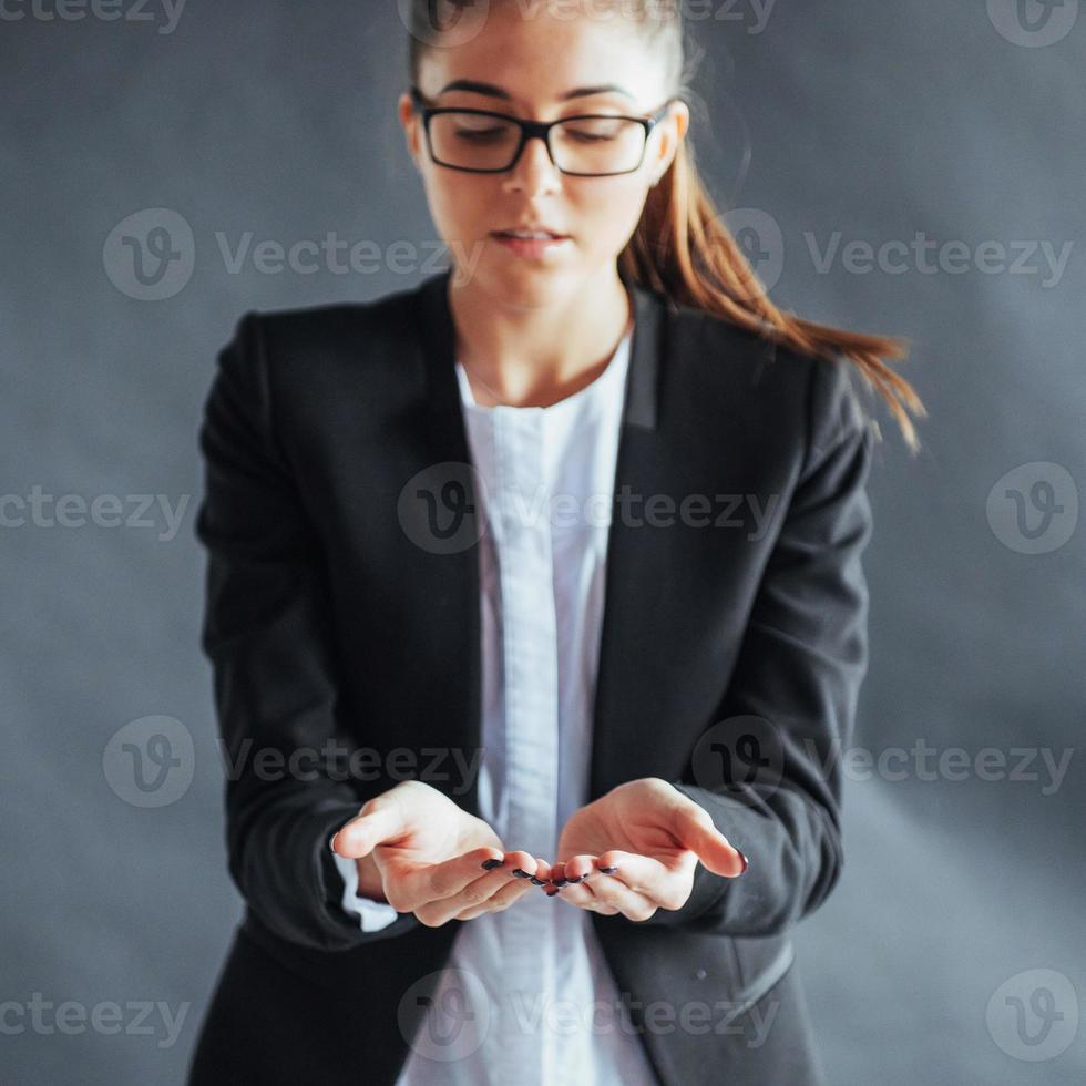 glimlachende jonge vrouw die iets op de palm van beide open handen toont foto