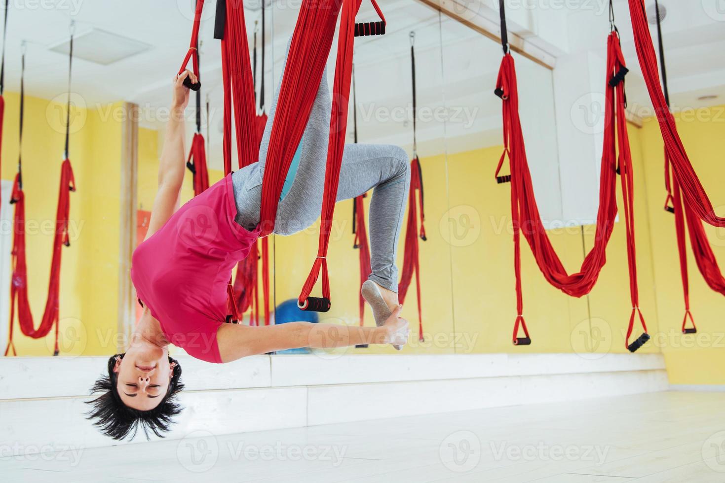 jonge vrouw antigravity yoga-oefeningen maken foto