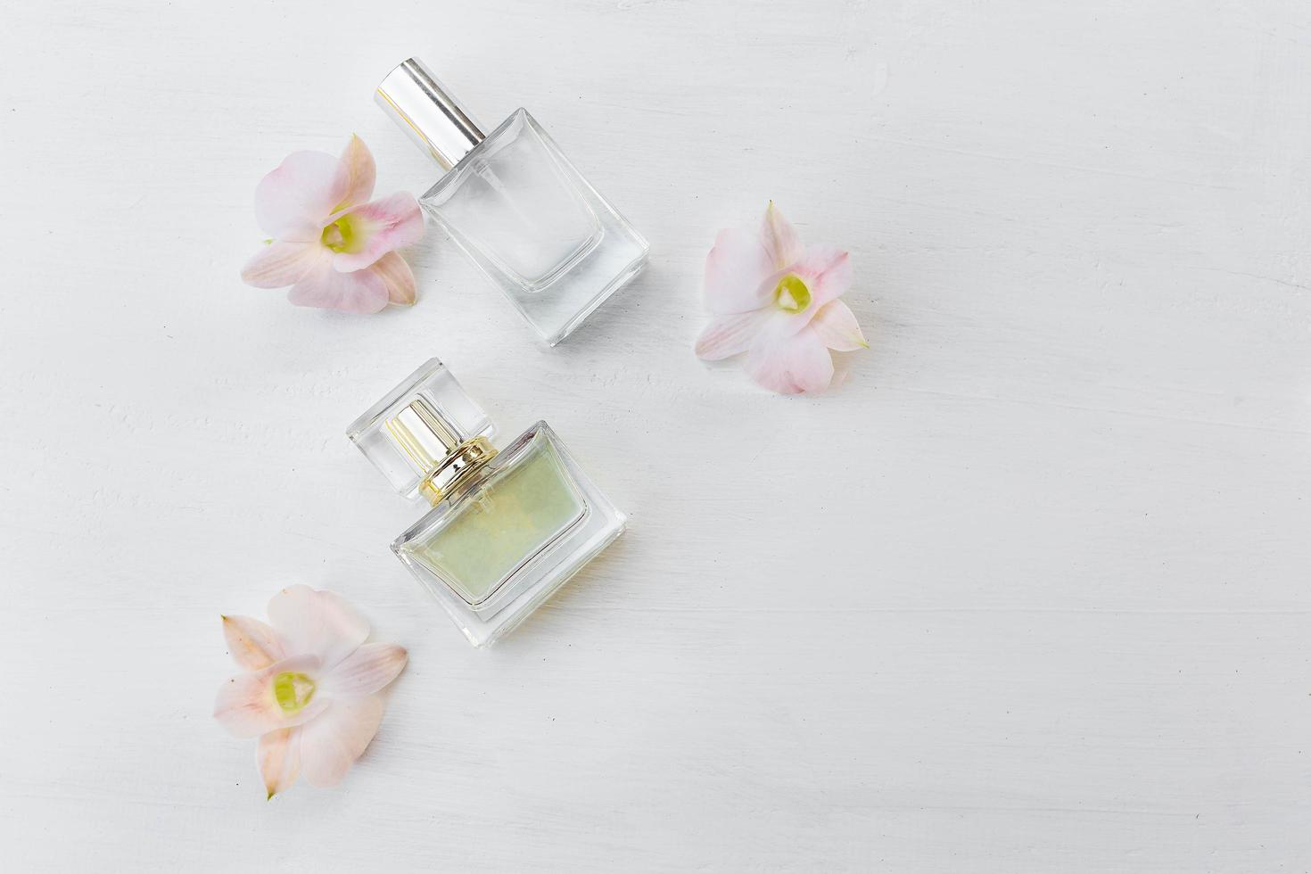 parfum en parfumflesje met roze bloemen foto