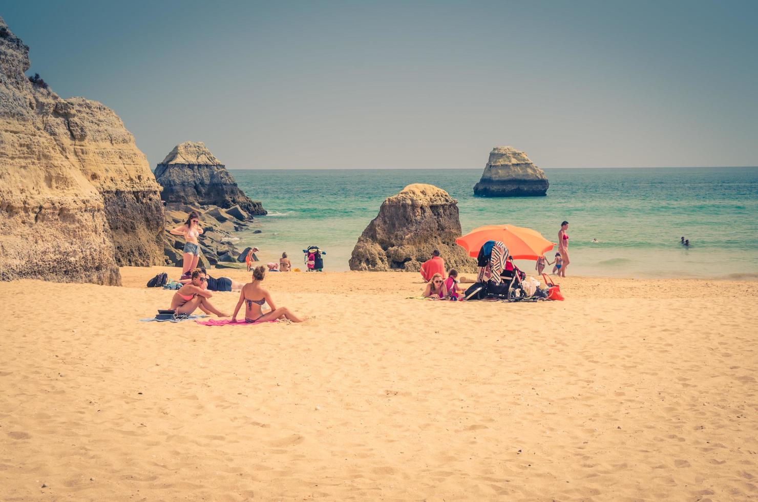 portimao, algarve, portugal, 19 juni 2017 praia de rocha strand met toeristen en kleurrijke parasols foto