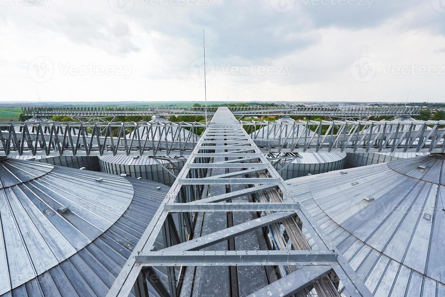 landbouw silo's. buitenkant van het gebouw. opslag en drogen van granen, tarwe, maïs, soja, zonnebloem tegen de blauwe lucht met witte wolken foto