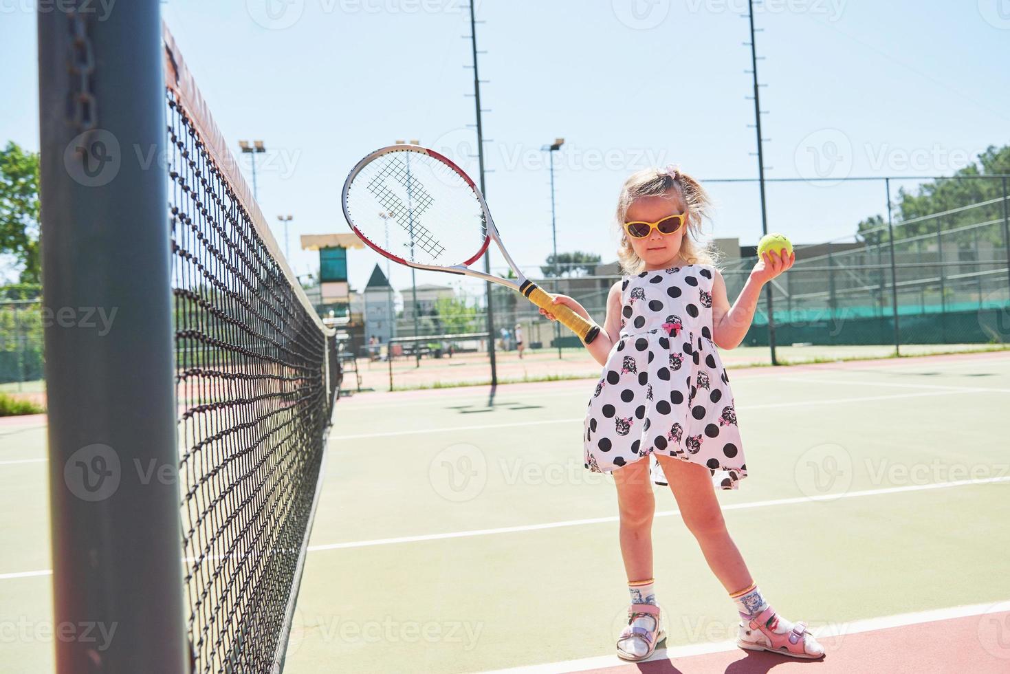 gelukkig klein meisje aan het tennissen foto