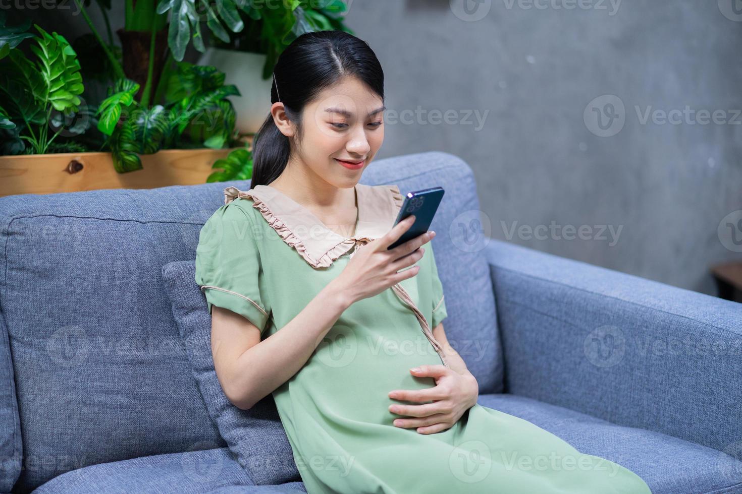 jonge Aziatische vrouw zwanger ontspannen thuis foto