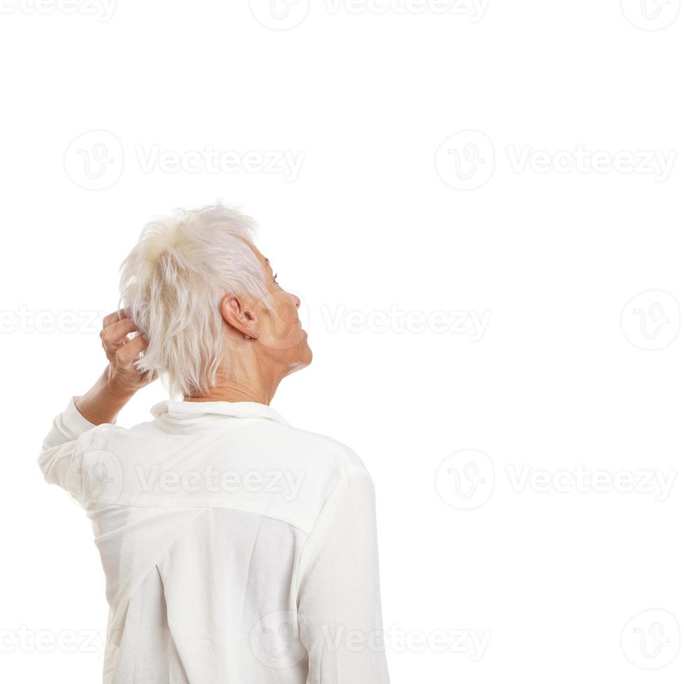 verbaasde oudere vrouw die haar hoofd krabt foto