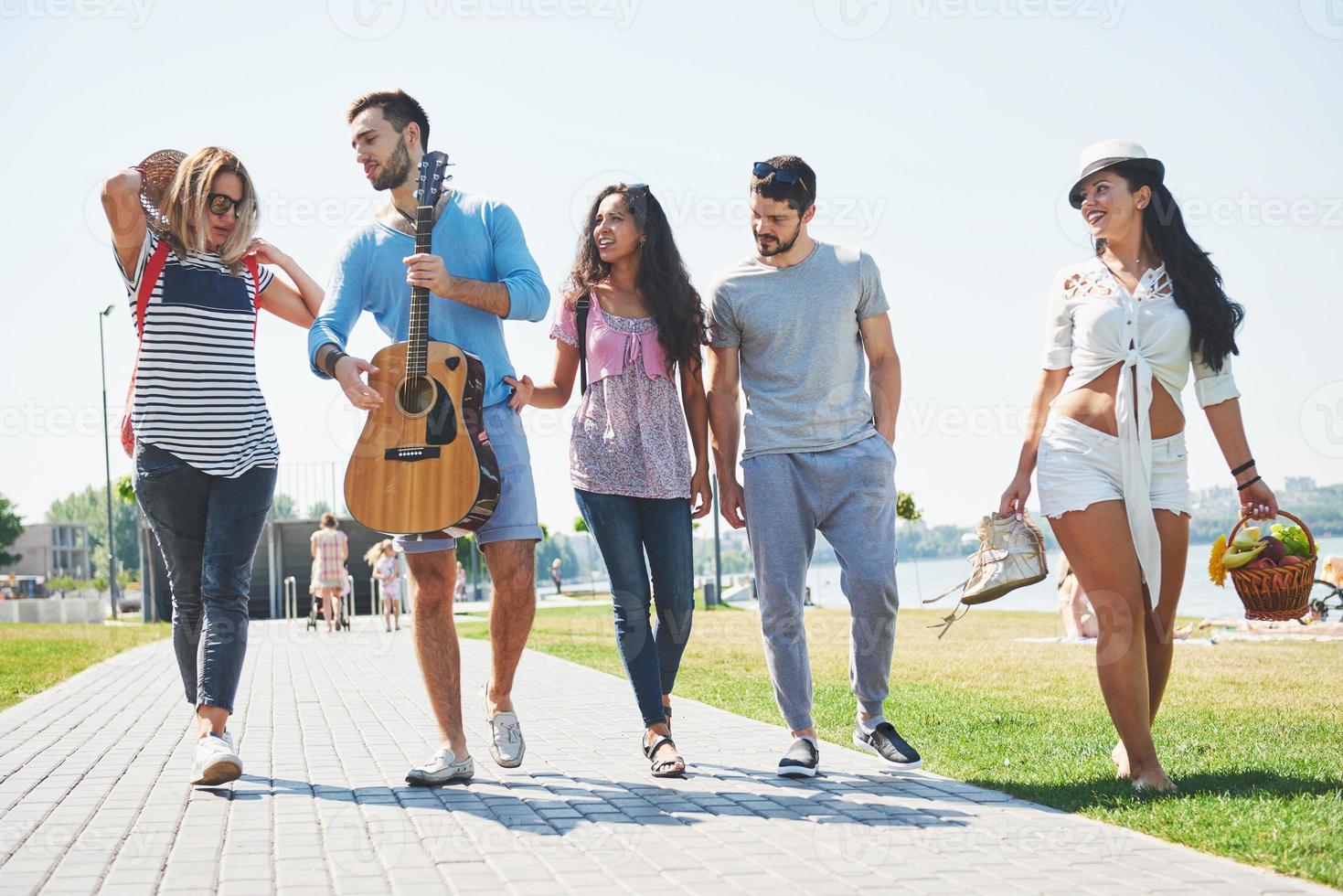 portret van een groep vrienden die op het strand gaan. gemengde groep vrienden wandelen op het strand op zomerdag foto